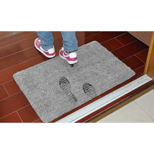 Super absorbent doormat at a doorway with footprints, showing how it soaks up water and dirt to keep floors clean.