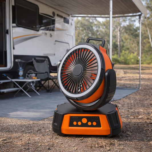 Orange and black portable fan on a camping ground with an RV in the background