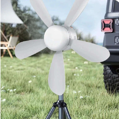 Portable ceiling fan on tripod beside caravan