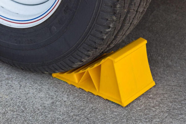Large yellow wheel chock for caravans, trailers, and motorhomes to prevent movement